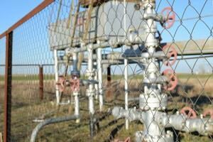 Grid the chain-link near an oil well. photo