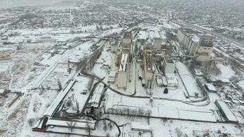 Grain terminal in the winter season. Snow-covered grain elevator in rural areas. A building for drying and storing grain. photo