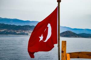 el bandera de Turquía revolotea en el viento en el cubierta de Placer yate. foto