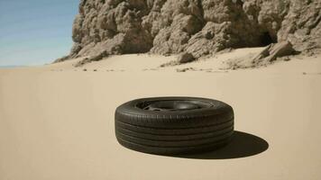 A tire sitting in the sand near a mountain video