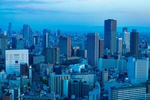 un oscuridad paisaje urbano por alto ángulo ver cerca el oficina edificios en Osaka foto