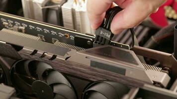 caucasian hand plugging in 8-pin ATX auxiliary power cable during GPU installation video