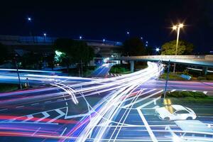 un noche lapso de tiempo de tráfico mermelada a el ciudad intersección en tokio amplio Disparo foto