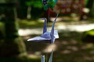 A paper crane swaying in the wind at the traditional street close up photo