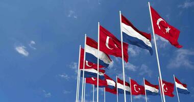 Netherlands and Turkey Flags Waving Together in the Sky, Seamless Loop in Wind, Space on Left Side for Design or Information, 3D Rendering video