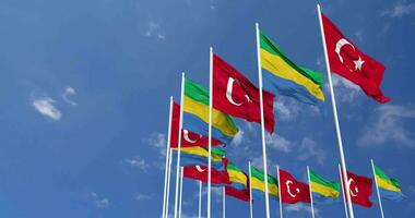 Gabón y Turquía banderas ondulación juntos en el cielo, sin costura lazo en viento, espacio en izquierda lado para diseño o información, 3d representación video