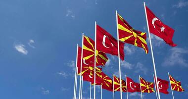 nord macedonia e tacchino bandiere agitando insieme nel il cielo, senza soluzione di continuità ciclo continuo nel vento, spazio su sinistra lato per design o informazione, 3d interpretazione video