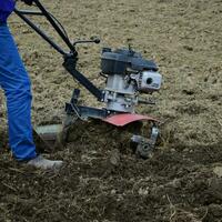 plantando patatas debajo el con operador a pie tractor foto