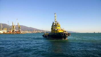 A small service ship in a cargo industrial port. A ship in the sea photo