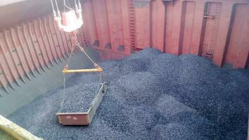 The cargo compartment of the ship, filled with coal. Loading of anthracite. Transportation of coal. photo