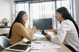 Two female accountants have a team meeting to summarize financial information in the office photo