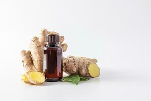 Natural ginger essential oil in a medical bottle on the background of ginger root and slices. The concept of moisturizing the skin. mock up photo