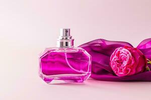 A chic bottle of women's perfume and a delicate chiffon scarf with a rosebud . Front view. Unnamed bottle for product introduction. photo