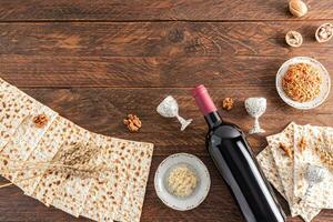 Traditional treats for the Jewish Passover holiday. matza, walnuts, a bottle of wine, parsley root. Top view. Wooden background. Flat lay. copy space photo