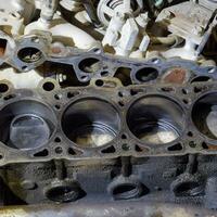 The cylinder block of the four-cylinder engine. Disassembled motor vehicle for repair. Parts in engine oil. Car engine repair in the service photo