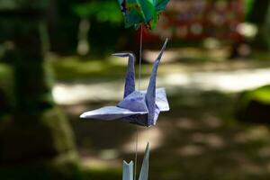 A paper crane swaying in the wind at the traditional street close up photo