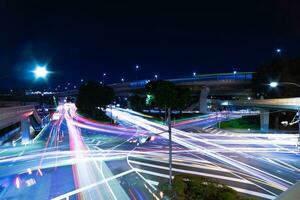 un noche lapso de tiempo de tráfico mermelada a el ciudad intersección en tokio amplio Disparo foto