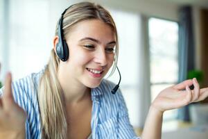 Young friendly operator woman agent with headsets. Beautiful business woman wearing microphone headset working in the office as a telemarketing customer service agent, call center job concept. photo