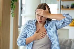 Breathing, respiratory problem, asthma attack, pressure, chest pain, sun stroke, dizziness concept. portrait of woman received heatstroke in hot summer weather, touching her forehead photo