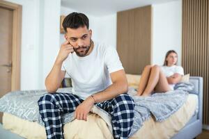 Couple With Problems Having Disagreement In Bed. Frustrated couple arguing and having marriage problems, Young couple into an argument on bed in bedroom photo