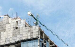 torre construcción grua en techo edificio construcción sitio con azul cielo antecedentes foto