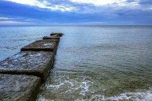 Beauty daily view with clouds of seashore with stone pier and clear water photo