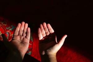 Islamic praying background photo. Muslim man praying with raising hands. photo
