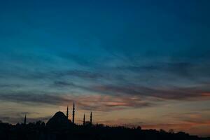 Ramadan or islamic concept photo. Silhouette of Suleymaniye Mosque at sunset. photo