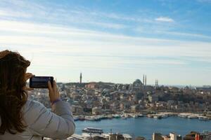 mujer tomando foto de Estanbul con su móvil teléfono desde galata torre