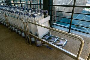Row of luggage trolleys or airport trolleys or luggage carts in an airport photo