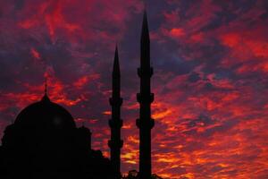 Islamic concept image. Silhouette of a mosque with dramatic clouds at sunset photo