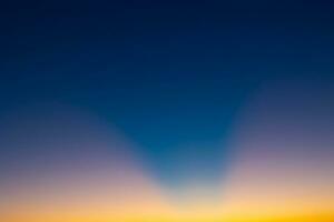 Crespuscular rays on the sky at sunset without clouds photo