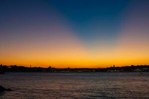 Istanbul skyline with crepuscular rays on the sky. photo