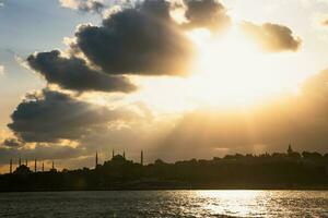 silueta de el histórico península de Estanbul y dramático nubes a puesta de sol foto