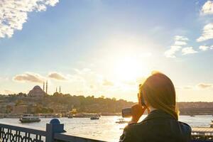 viaje a Estanbul. turista mujer tomando un foto de Estanbul a puesta de sol
