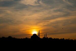 Suleymaniye Mosque and sun at sunset. Dramatic view of Istanbul at sunset photo