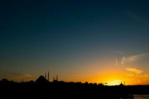 Estanbul horizonte a puesta de sol. suleymaniye mezquita y fatih mezquita silueta foto