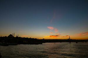 Istanbul skyline. Silhouette of Istanbul at sunset from Galata Bridge photo