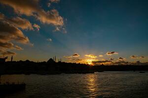 Silhoeutte of Istanbul at sunset with dramatic clouds and sunrays photo