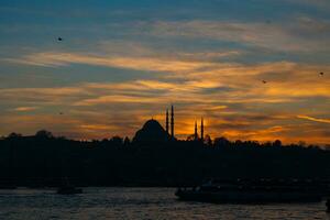 Istanbul silhouette background. Silhouette of Suleymaniye Mosque at sunset. photo
