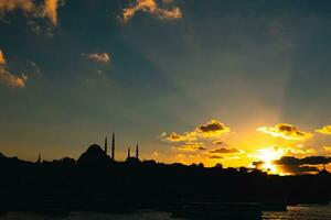 Istanbul silhouette. Sunlight rays and Suleymaniye Mosque at sunset photo