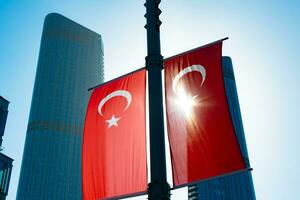 Turkish Flags in focus and skyscrapers on the background. photo