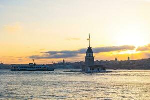 Maiden's Tower aka Kiz Kulesi with a ferry at sunset. Landmarks of Istanbul photo