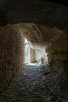 L'Aquila, Italy-august 12, 2021-ruins of the Hermitage of the Holy Spirit an ancient church dug into a cliff with a well-preserved fresco, altar and hermit's cells. photo