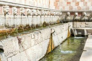 L'Aquila, Italy-august 11, 2021-Particular of the Fountain of 99 Spouts during a sunny day photo