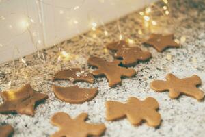 Making traditional Christmas cookies. Figured gingerbread cookies kitchen table with holiday lights photo