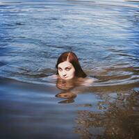 young woman swimming in lake or bathing pond photo