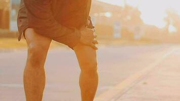 Attractive young man stretching in the park before running at the sunset focus on shoes video