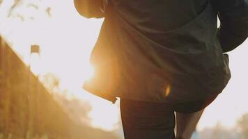 Attractive young man stretching in the park before running at the sunset focus on shoes video