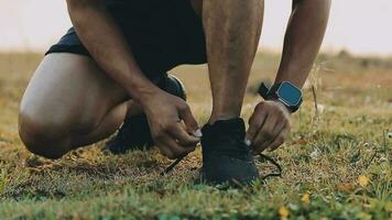 atractivo joven hombre extensión en el parque antes de corriendo a el puesta de sol atención en Zapatos video